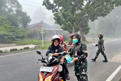 Prajurit TNI AU Bagikan Masker untuk Jaga Kesehatan Warga dari Asap Karhutla